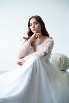 portrait of beautiful young woman in white wedding dress posing in studio