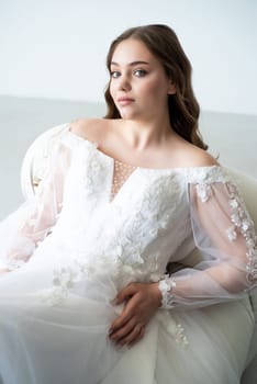 portrait of beautiful young woman in white wedding dress posing in studio