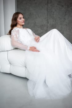 portrait of beautiful young woman in white wedding dress posing in studio