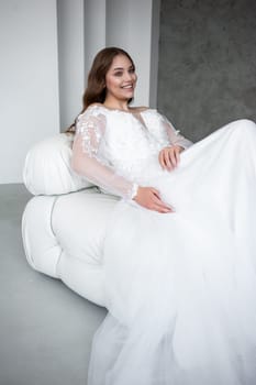 portrait of beautiful young woman in white wedding dress posing in studio