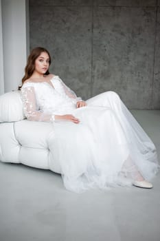 portrait of beautiful young woman in white wedding dress posing in studio