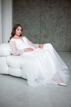 portrait of beautiful young woman in white wedding dress posing in studio