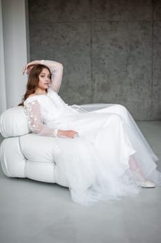 portrait of beautiful young woman in white wedding dress posing in studio