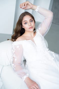 portrait of beautiful young woman in white wedding dress posing in studio