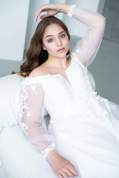 portrait of beautiful young woman in white wedding dress posing in studio