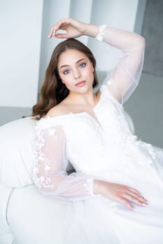 portrait of beautiful young woman in white wedding dress posing in studio