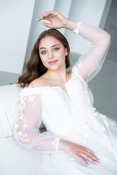 portrait of beautiful young woman in white wedding dress posing in studio