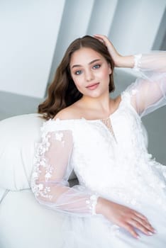 portrait of beautiful young woman in white wedding dress posing in studio