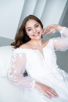 portrait of beautiful young woman in white wedding dress posing in studio