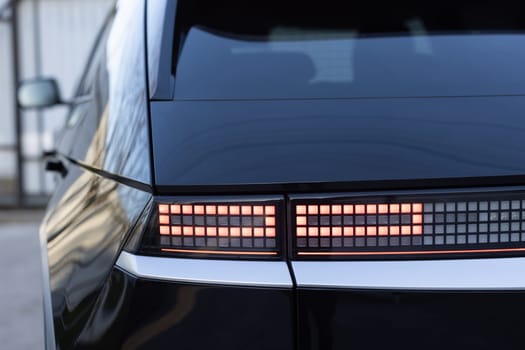 Close up detail on one of the LED red taillight modern luxury car. Car back lights shining. Exterior detail automobile. Tail light car. Detail on the rear light of a car.