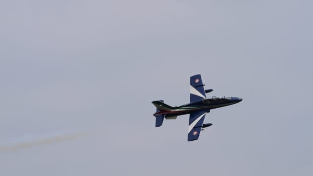 Istrana Italy April 5 2024: Isolated Small Military Airplane in Flight with White Smoke. Aermacchi MB-339 of Frecce Tricolori the Italian Air Force Aerobatic Team. Copy Space