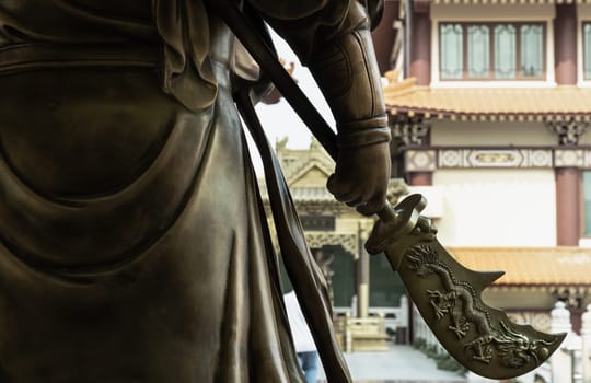 Bangkok, Thailand - Apr 11, 2024 - Green dragon crescent blade (Halberd) weapon of Sangharama Bodhisattva (Buddhist deity). Sangharama deity at Fo Guang Shan Thaihua Temple, Space for text, Selective focus.