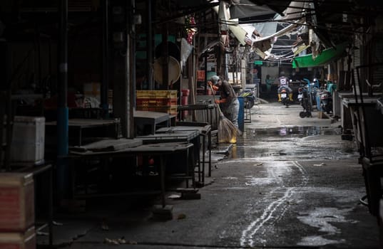 Bangkok, Thailand - Apr 11, 2024 - The atmosphere of the food market was closed at noon, and the old lady was cleaning after the market closed. Space for text, Selective focus.