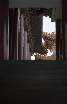 Bangkok, Thailand - Apr 11, 2024 - Perspective exterior view of Gable roof and slab of colored tiles on temple wall at Fo Guang Shan Thaihua Temple. Space for text, Selective focus.