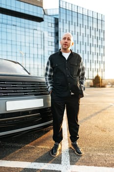 Casual man standing near his luxury car at the parking close up