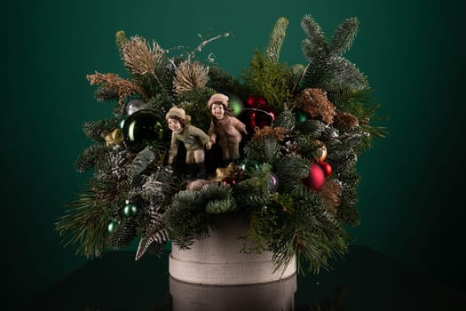 A festive holiday arrangement featuring cuddly teddy bears and sparkling ornaments in red, green, and gold colors. The teddy bears are wearing Santa hats and the ornaments are delicately placed around them.