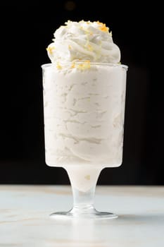 Mousse dessert with cream in glass on the table close up