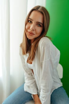 Portrait of attractive lovely girl wearing crop top and shirt posing over green studio background close up