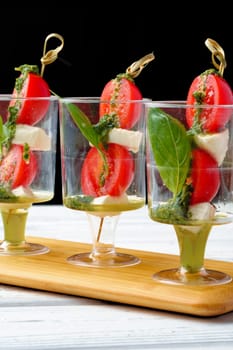 Caprese canapes in glasses on a skewer close up