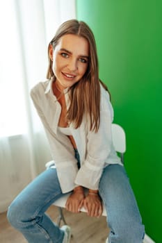 Portrait of attractive lovely girl wearing crop top and shirt posing over green studio background close up