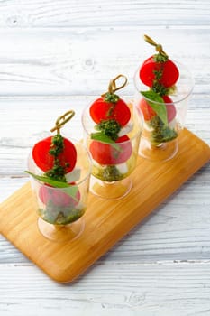 Caprese canapes in glasses on a skewer close up