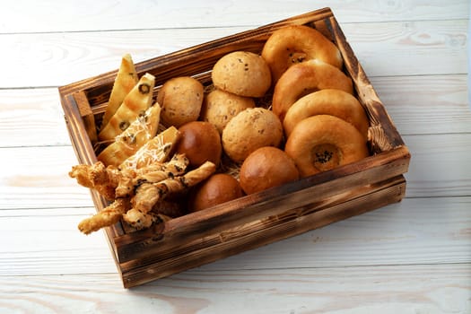 Bakery products in straw bread basket on wooden table close up
