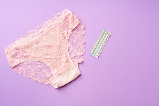 Woman panties with birth control pills top view flat lay