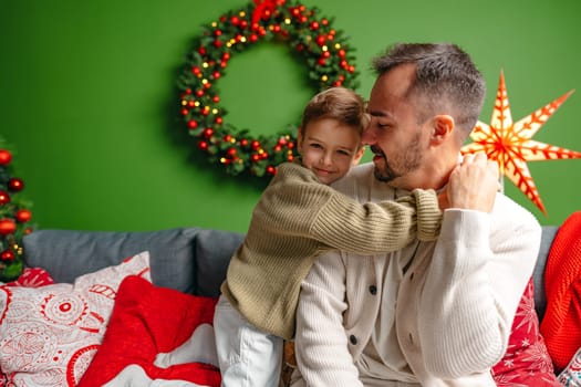 Young dad and his son celebrate Christmas together at home close up