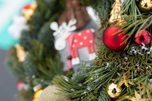 A detailed view of a Christmas wreath adorned with colorful ornaments, showcasing intricate details and festive decorations. The ornaments are arranged neatly on the wreath, adding a touch of holiday cheer to the scene.