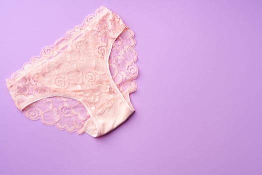 Women's panties on pink background with copy space flat lay