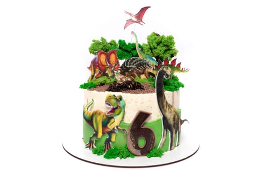 A birthday cake adorned with intricately designed edible dinosaurs and plants. The cake features a prehistoric theme with miniature dinosaur figures and lush greenery made of icing, creating a whimsical and fun design for a celebration.