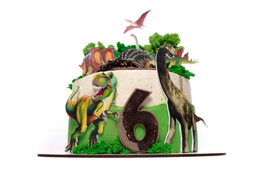 A birthday cake decorated with a dinosaur theme, featuring a number six candle on top. The cake is colorful and vibrant, with dinosaur figurines as decorations.