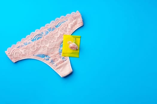 Women's panties with sanitary pad on color background top view