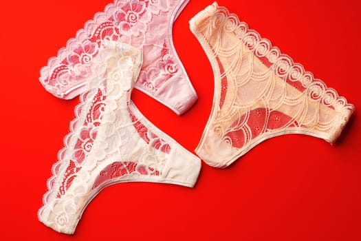 Classic women's panties on a bright red background flat lay