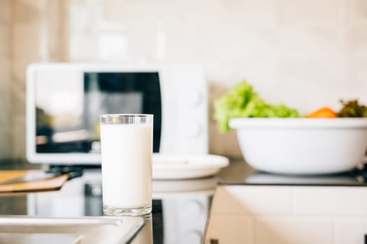 Glass of milk on rustic kitchen table. Empty space for product display. Fresh morning drink for organic diet. Clean transparent jug nature protein source. Modern design give me. Healthy eating concept