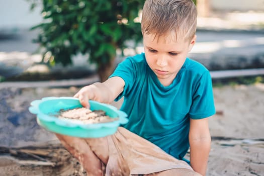 Child playing in sandbox. Happy childhood freedom creativity development, tactile Nature sensations.