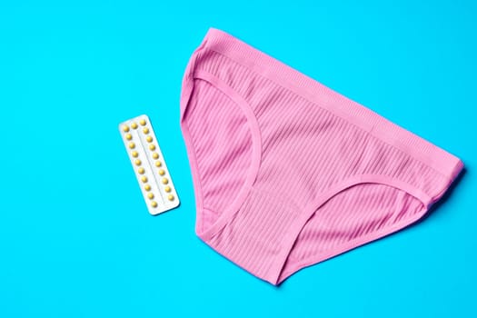 Woman panties with birth control pills top view flat lay