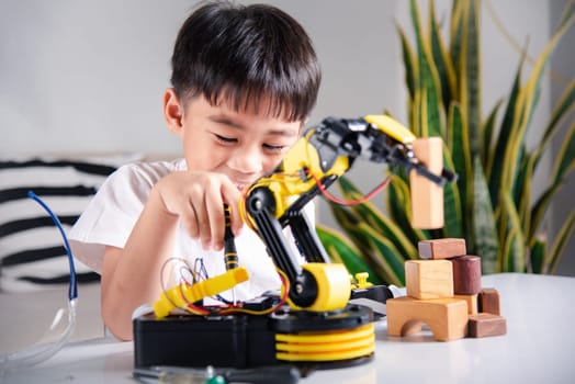Child learning repairing getting lesson control robot arm, Happy Asian little kid boy using screwdriver to fixes screw robotic machine arm in home workshop, Technology future science education concept