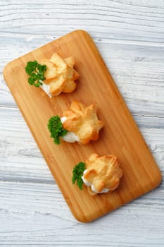 Profiteroles stuffed with soft mousse banquet food snacks close up