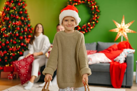 Happy family in the room with the Christmas tree at home close up