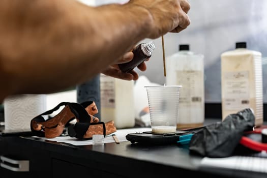 Close up photo of man car service worker making glue for applying car protective film