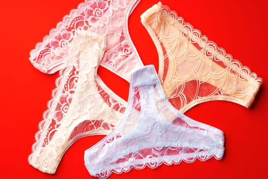 Classic women's panties on a bright red background flat lay