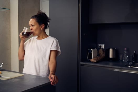 Young pretty woman drinking coffee in the home kitchen