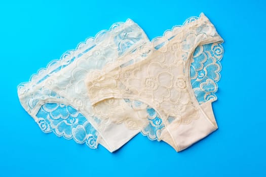 Women's panties on a blue background in studio top view