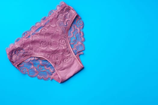 Women's panties on a blue background in studio top view