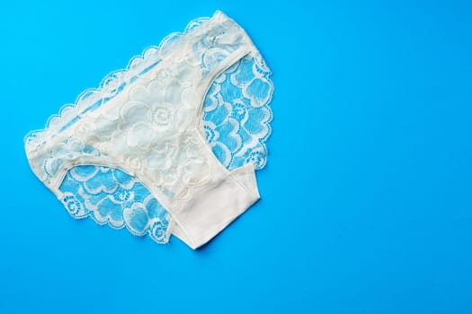 Women's panties on a blue background in studio top view