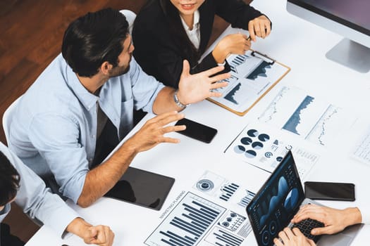 Analyst team utilizing BI Fintech to analyze financial data at table in meeting room. Businesspeople analyzing BI dashboard power on paper for business insight and strategic marketing planning.Prudent