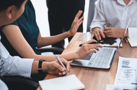 Multiracial analyst team use BI dashboard data to analyze financial report on meeting table. Group of diverse business people utilize data analysis by FIntech for success business marketing. Concord