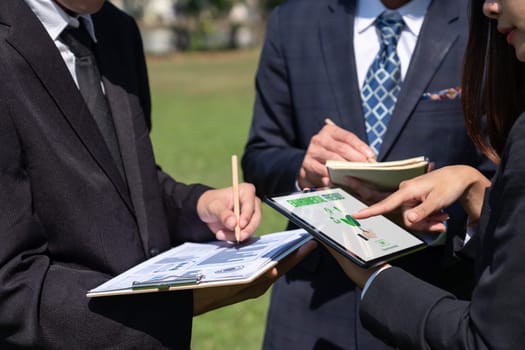 Group of asian business people presenting environmentally friendly development plan and sustainable technology project for greener future, establishing outdoor eco business office at natural park.Gyre