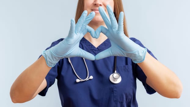 Nurse in scrubs forming heart shape with gloved hands, healthcare concept for poster and card.
